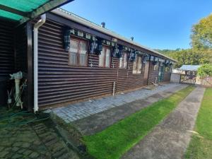 a wooden house with a grass yard next to it at Annes Place in Vosburg