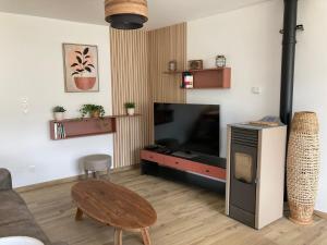un salon avec une grande télévision et une table dans l'établissement Entre Terre et Mer Meublé de tourisme 3 étoiles, à Colomby-sur-Thaon
