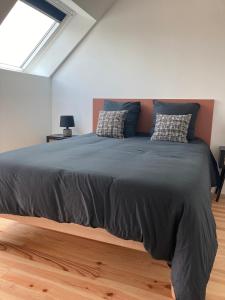 un grand lit dans une chambre avec une fenêtre dans l'établissement Entre Terre et Mer Meublé de tourisme 3 étoiles, à Colomby-sur-Thaon 3 autres photos