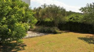 a garden with a stone pathway and trees at Apartman Rabtours in Kampor +3 photos