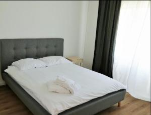 a bed with white sheets and pillows in a bedroom at Apartman Rabtours in Kampor