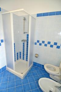 a blue and white bathroom with a shower and a toilet at Ginestra ONE 30m Front SEA by Salento Prime in Torre Vado