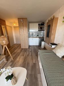 Una pequeña habitación con una cama y una cocina. en Bel appartement en bord de mer, en Lacanau