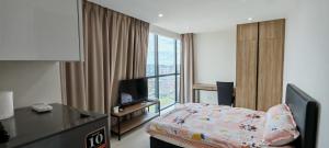 a hotel room with a bed and a television at Stunning View III Kozi square in Kuching