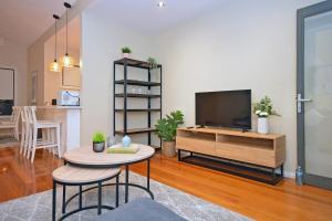 una sala de estar con un televisor y una mesa en Luxury Townhouse Stay, en Melbourne