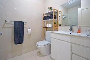 Un baño con inodoro, lavabo y espejo. en Luxury Townhouse Stay, en Melbourne 10 fotos más