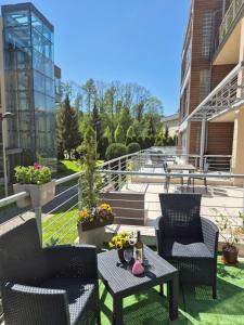 a patio with two chairs and a table at Apartament z tarasem Zeta Park in Ustroń