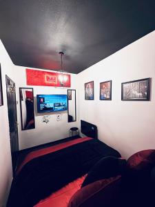 a bedroom with a bed and pictures on the wall at Play Queen - A Playful Unique Hot Tub Retreat in Sedgley