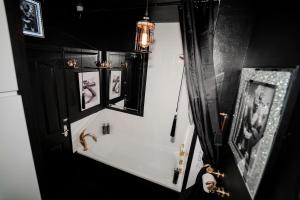 a bathroom with a sink and a mirror at Play Queen - A Playful Unique Hot Tub Retreat in Sedgley