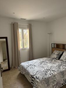 ein Schlafzimmer mit einem Bett, einem Spiegel und einem Fenster in der Unterkunft 3 chambres à côté de sarlat, dans le Périgord ! in Carsac-Aillac