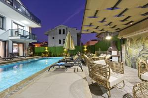 a villa with a swimming pool with chairs and a table at BENDİS - Villa for 8 People in the center of Fethiye in Fethiye