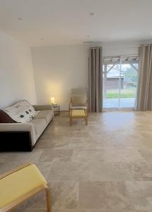 ein Wohnzimmer mit einer Couch und einem Sessel in der Unterkunft 3 chambres à côté de sarlat, dans le Périgord ! in Carsac-Aillac