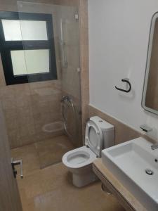 ein Badezimmer mit Toilette, Dusche und Waschbecken in der Unterkunft 3bedroom chalet swan lake north coast-388A in Zāwiyat al ‘Awwāmah
