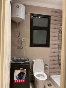 une petite salle de bain avec toilettes et fenêtre dans l'établissement Modern Studio 1BR, Celia TMG, New Administrative, New Capital, Fully Equipped, King Bed, Ground Floor, à Kafr ash Sharā‘inah