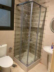 une cabine de douche dans une salle de bain avec toilettes dans l'établissement Modern Studio 1BR, Celia TMG, New Administrative, New Capital, Fully Equipped, King Bed, Ground Floor, à Kafr ash Sharā‘inah