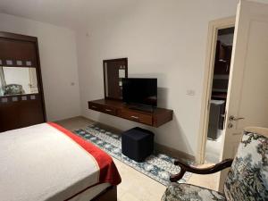 une chambre avec un lit et une télévision à écran plat dans l'établissement Modern Studio 1BR, Celia TMG, New Administrative, New Capital, Fully Equipped, King Bed, Ground Floor, à Kafr ash Sharā‘inah