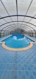 a large swimming pool with a large ceiling at Sunset retreat lodge with large wrap around decking in Newquay