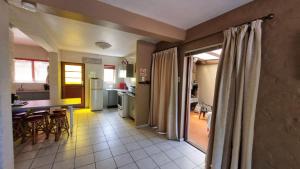 a kitchen and living room with a table and chairs at ANASTASIS, SEABREEZE CABANAS in George