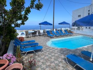 um pátio com cadeiras e uma piscina com vista em Stella Nomikou Apartments em Firostefani