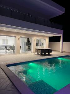 a swimming pool in front of a house at night at Villa roche in Awlād ‘Umar