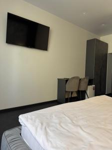 a bedroom with a bed and a tv on the wall at Moyenne Apart Hotel in Rivne