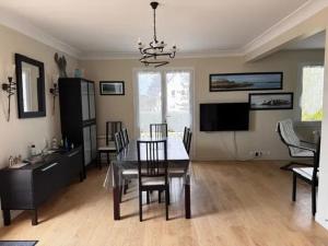 a dining room with a table and chairs and a television at Maison de Campagne Familiale à Portbail - 6 personnes in Portbail