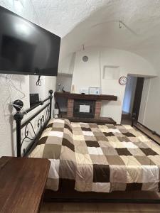 a bedroom with a checkered bed and a tv at Casa Grande appartamento Marianna in Pragelato