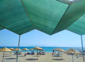 a group of umbrellas and chairs on a beach at Mandarin Beach Hotel in Gumuldur