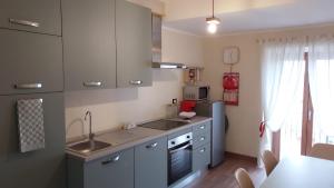a kitchen with a sink and a stove top oven at Pasubio 13 in Selvino