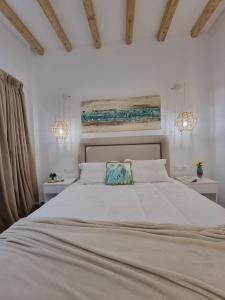 a bedroom with a large white bed with two night stands at Europa Studios in Skala +18 photos