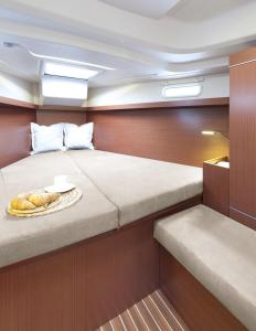 a bed on a boat with a plate of bread at ''Alkyoni" Sailing Yacht in Thessaloniki