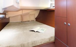 a small room with a bed with a book on it at ''Alkyoni" Sailing Yacht in Thessaloniki
