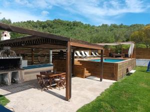 a pavilion with a pool and a table and chairs at Villa Thanos in Marathias