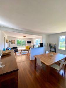 een eetkamer en woonkamer met een tafel en stoelen bij Bourdaines - Villa entre océan et forêt in Seignosse