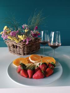 a plate of strawberries and oranges and two glasses of wine at Spiaggiabella Resort in Torre Rinalda