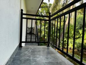 einen Balkon eines Hauses mit einem schwarzen Geländer in der Unterkunft The Divines Edge in Hikkaduwa