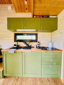 a kitchen with green cabinets and a counter top at Tiny Home in Dejani +27 photos