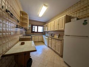 a kitchen with a refrigerator and a table in it at Villa Maadi 35 -R 206 - Pool View Master Room in Cairo