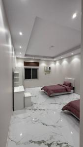 a bedroom with two beds and a marble floor at شقة بأثاث فُندقي in Al Madinah