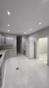 an empty kitchen with a refrigerator and a stove at شقة بأثاث فُندقي in Al Madinah +17 photos
