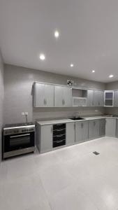 a large kitchen with white cabinets and a stove at شقة بأثاث فُندقي in Al Madinah