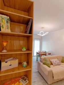 a living room with a couch and a book shelf at Private Parking - Modern Apartment Near Assisi in Bastia Umbra