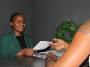 a woman sitting at a table receiving a piece of paper at Motse River Lodge in Vosburg
