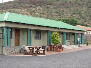a building with picnic tables in front of it at Motse River Lodge in Vosburg