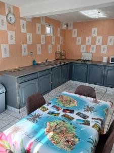 a kitchen with a table and chairs and a sink at Maison au Bois-Court in Le Tampon