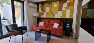 カルカソンヌにあるEntrez en lice, Face à la Cité vue sublimeのリビングルーム(赤いソファ、椅子2脚付)