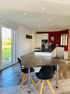 a kitchen with a large wooden table and chairs at Alice Cottage in Cléder