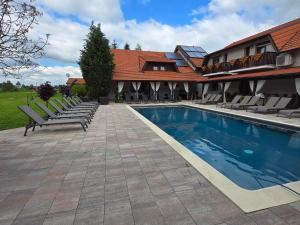 a swimming pool with lounge chairs next to a house at House Tina in Grabovac +23 photos