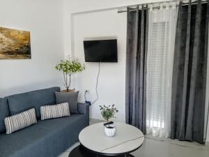 a living room with a blue couch and a table at Lilac Kefalos in Kefalos
