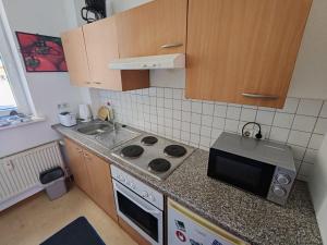 a small kitchen with a stove and a microwave at Apartment in der Nordhäuser Altstadt in Nordhausen